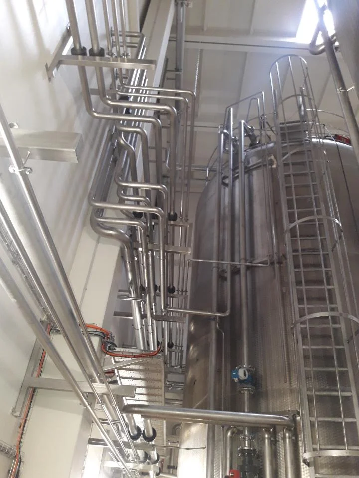 Wysokie stalowe zbiorniki i rury instalacyjne w nowoczesnym zakładzie przemysłowym.