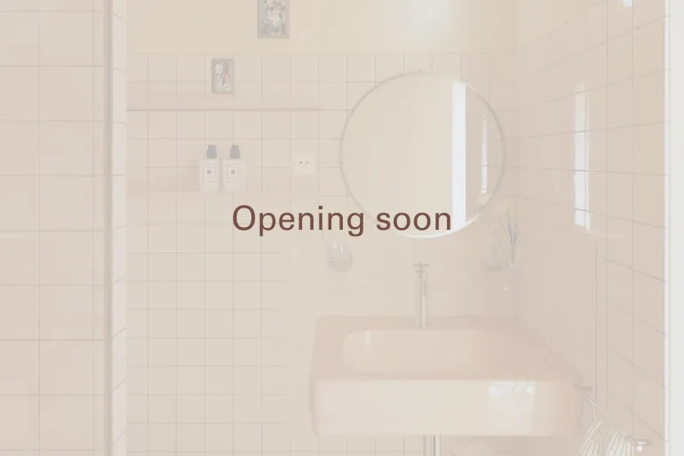 Aperçu filtré et transparent d'une salle de bain moderne Anchor avec grand miroir rond, marqué Opening soon.