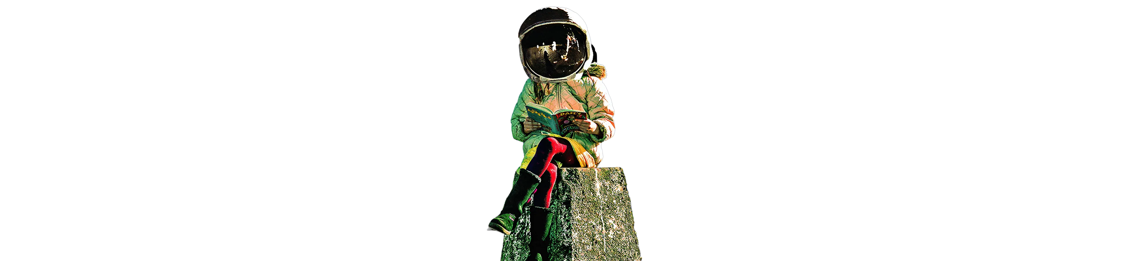Person wearing an astronaut helmet and winter clothing sitting on a rock and reading a book.