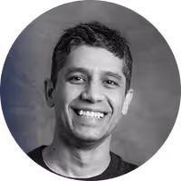 Portrait of a smiling man with short dark hair in black and white.