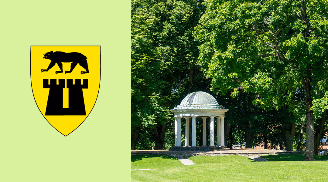 White domed pavilion with columns in green park with leafy trees under sunlight.