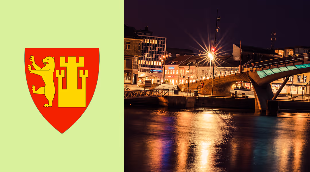 Night view of a lit bridge over water with buildings and reflections at night in Fredrikstad.