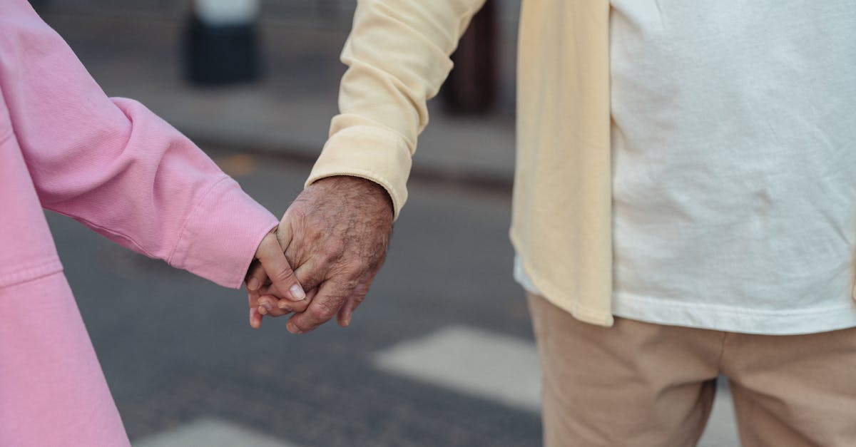 Cuidadora familiar sénior a apoiar a mão de pessoa idosa com Alzheimer, num ambiente doméstico calmo em Portugal