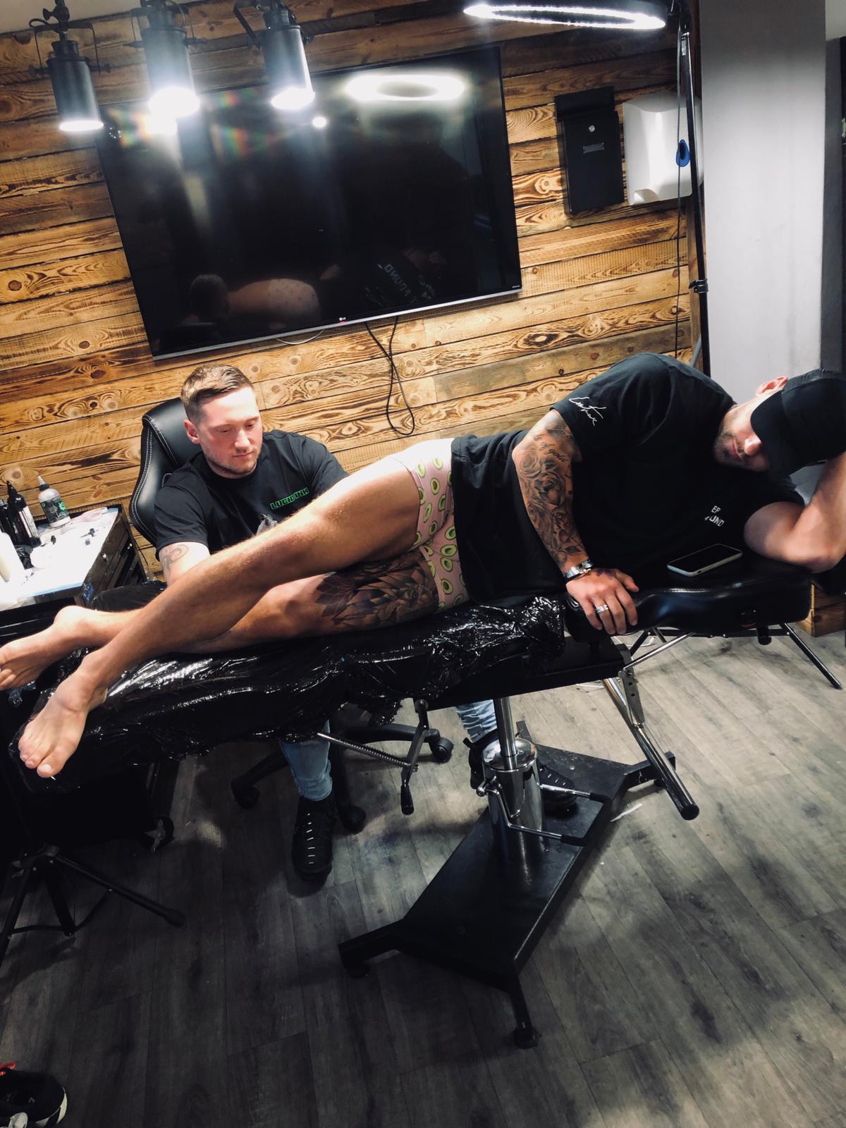 Joss Mooney during a tattoo session with Joshua