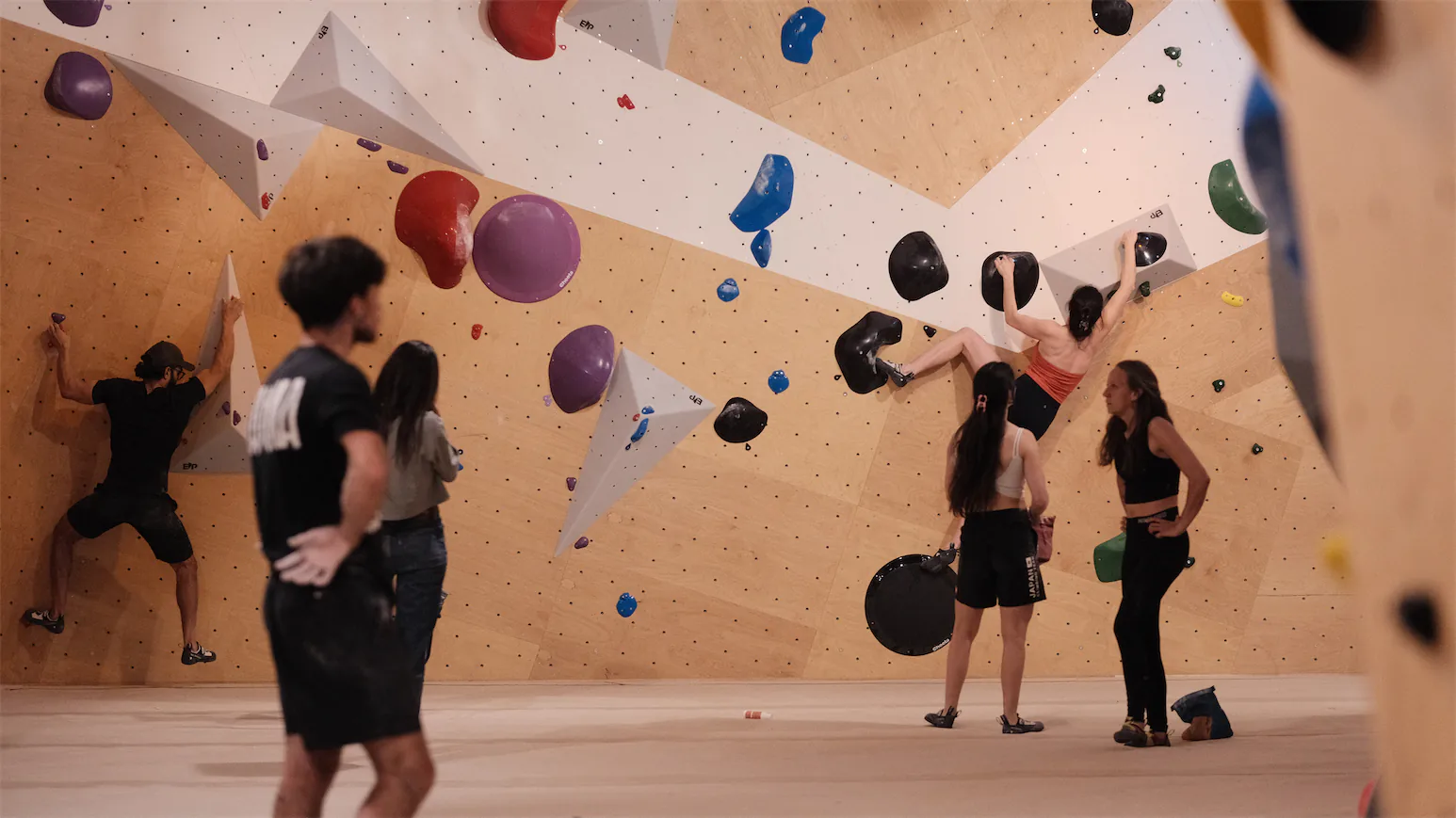 Session de groupe devant le mur d'escalade de bloc.