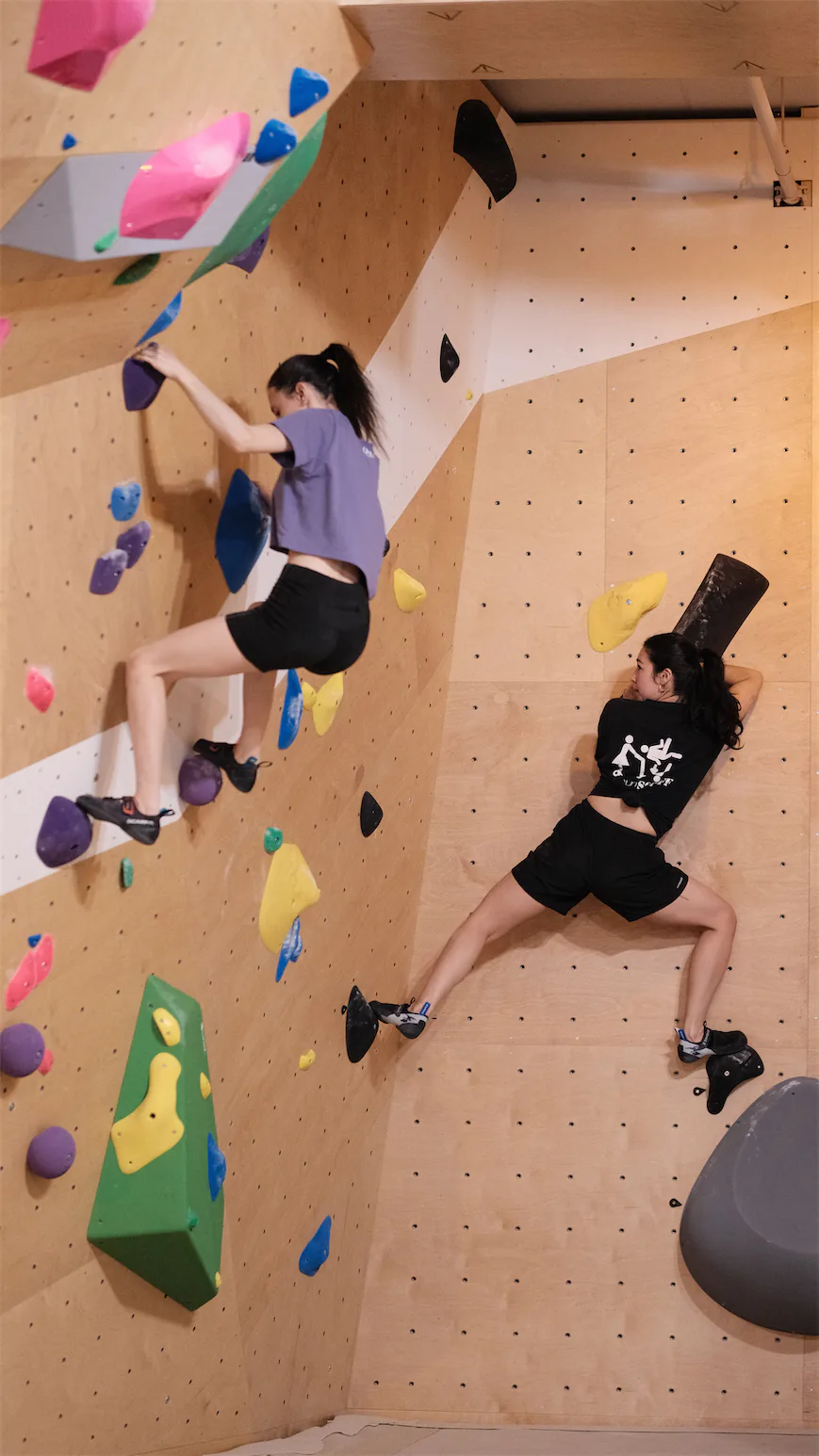 Deux grimpeuses évoluent sur un mur de bloc Climb World.