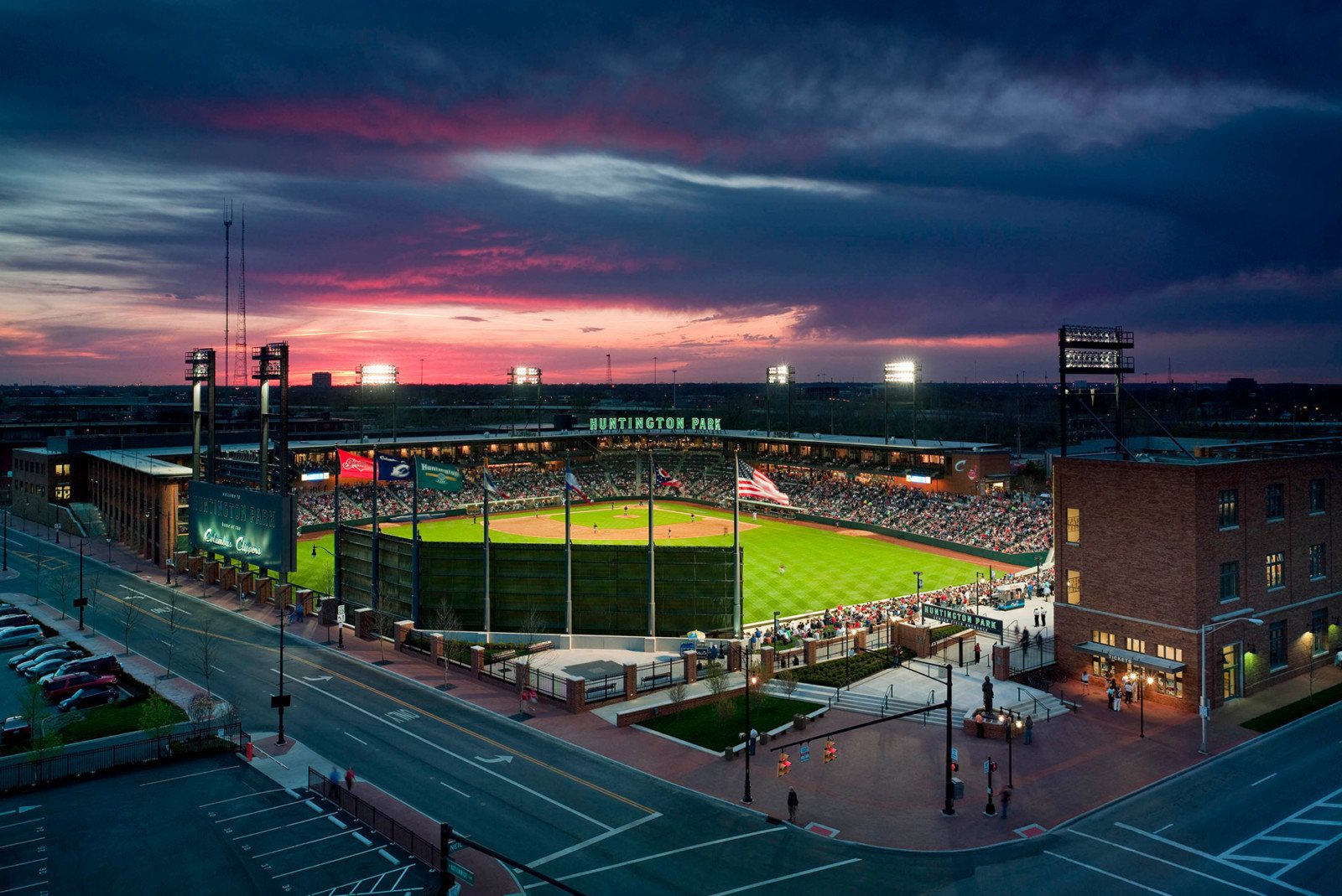 Huntington Park baseball stadium at dusk with field lights on and a crowd watching the game.