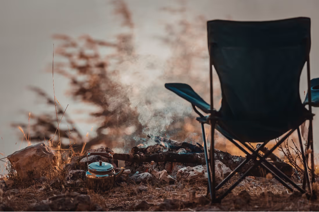 Campingstuhl an einer Feuerstelle im Freien