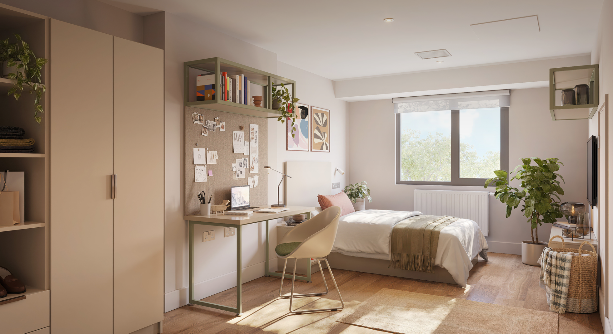 Sunlit bedroom with a neatly made bed, workspace desk with laptop, beige wardrobe, decorative plants, and large window showing trees outside.