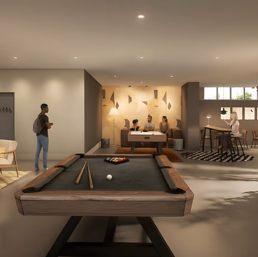 Modern game lounge featuring a billiards table in the foreground with cues and balls, a group of three people sitting on a couch playing an air hockey table, and a woman sitting at a high table with stools on a patterned rug.