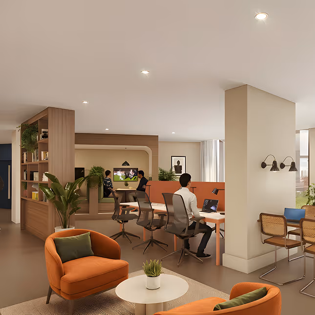 Modern office lounge with orange armchairs, round table, workspace desks with people working on laptops, and plants.