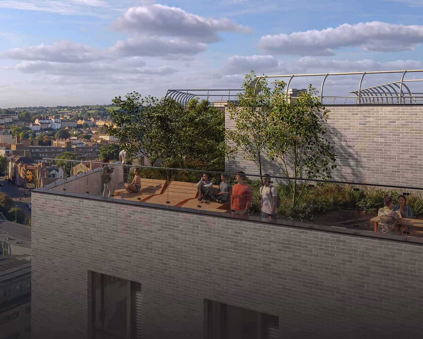 Rooftop terrace with glass railing, trees, plants, wooden deck seating, and people socializing under a partly cloudy sky.