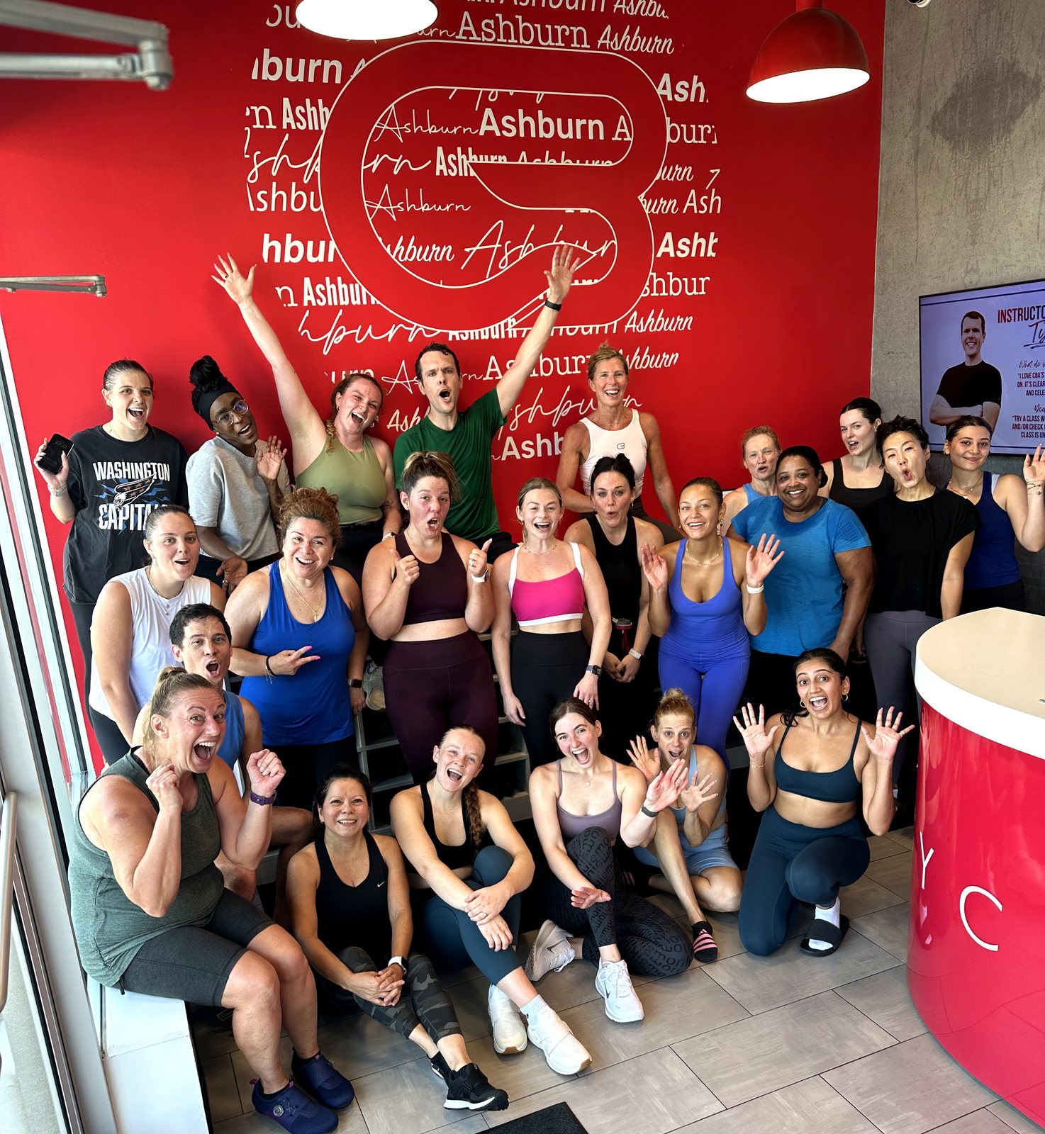 Riders cheering after a group indoor cycling class at CycleBar Ashburn in Ashburn, VA