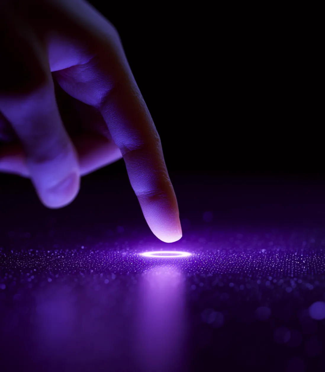 A person's finger touching a glowing purple circular light on a dark, textured surface.