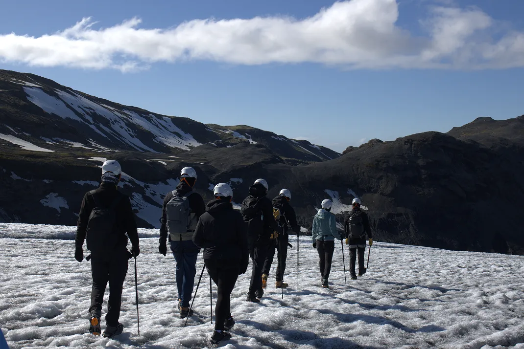 Group of hikers exploring Sólheimajökull glacier during guided tour with experienced guide