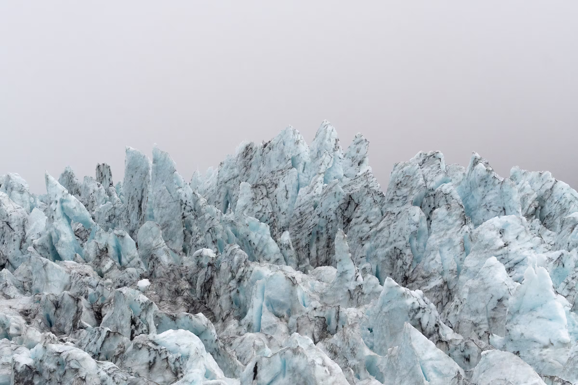 Small group hiking on blue glacier ice in Iceland in winter