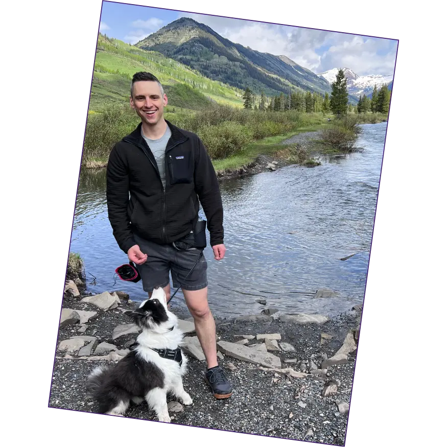 Dr. Anthony Davis hiking with his dog near a lake in the mountains