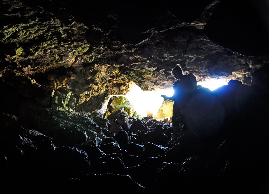 Natural cave entrance in a wooded setting, representative of Crystal Cave in Bella Vista, Arkansas