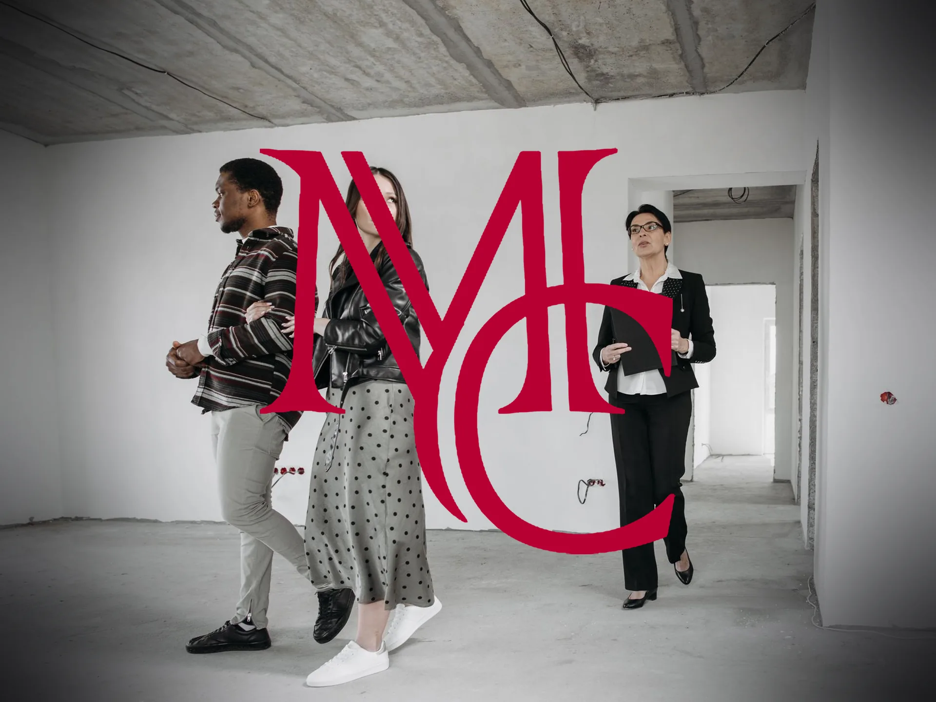 A couple touring an unfinished concrete-frame apartment unit with a leasing agent holding a clipboard — MCG