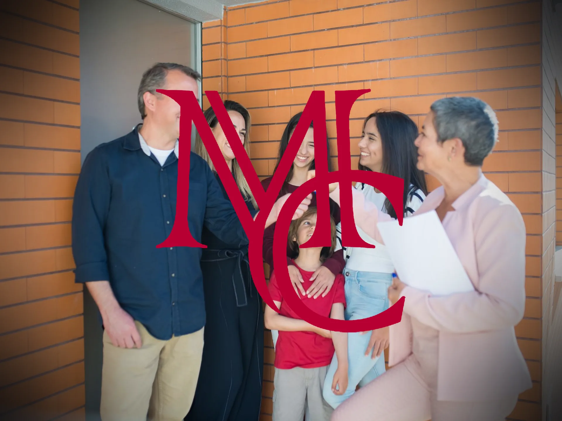 A family receiving keys from a real estate agent outside a brick home — MCG