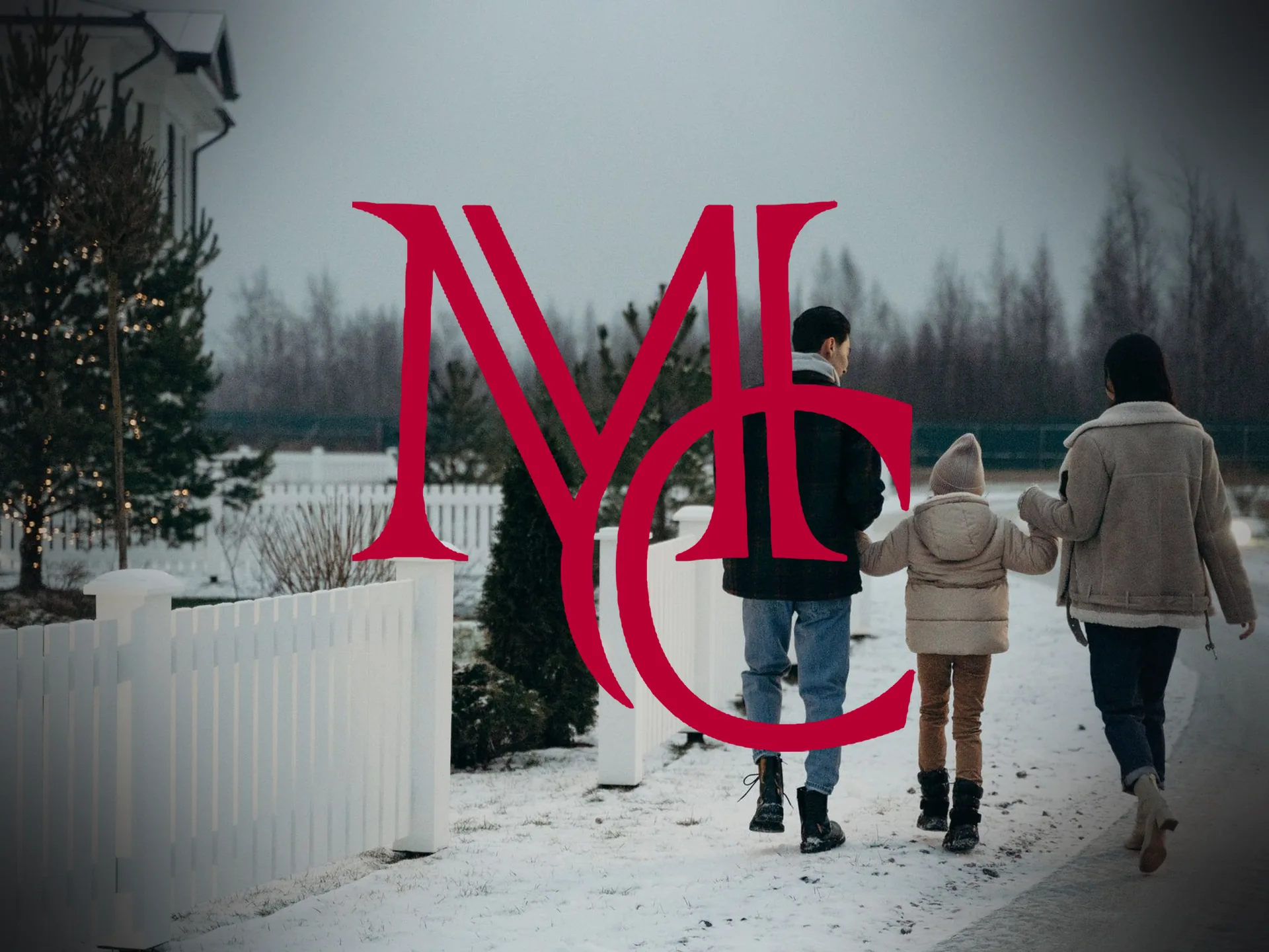 A family walks along a snowy sidewalk past a white picket fence in a Bentonville, AR neighborhood — MCG