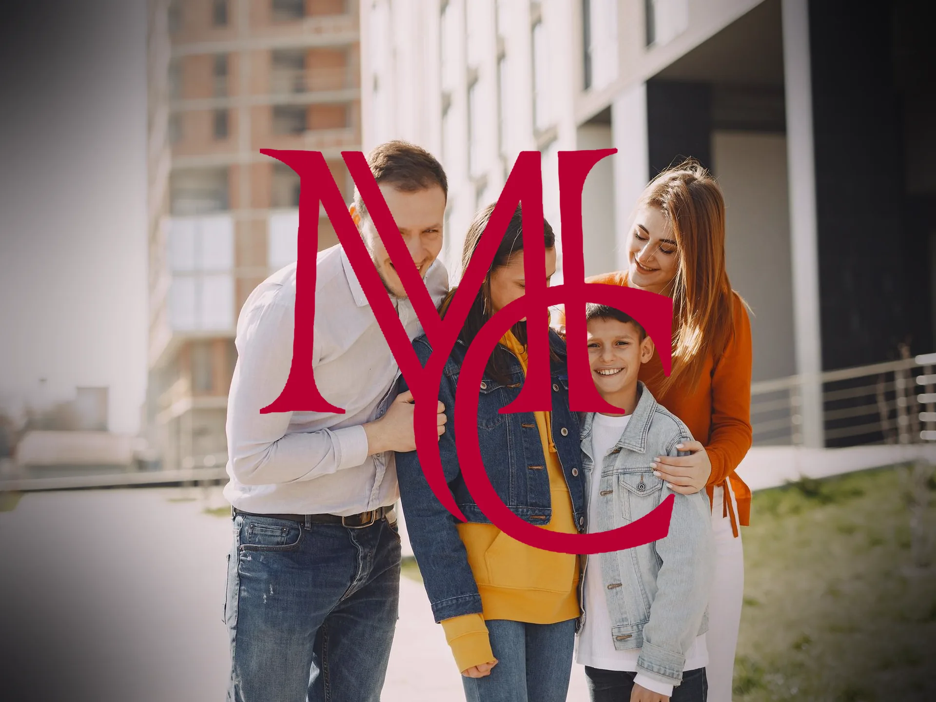 A family of four standing together outside a modern multi-story residential building — MCG