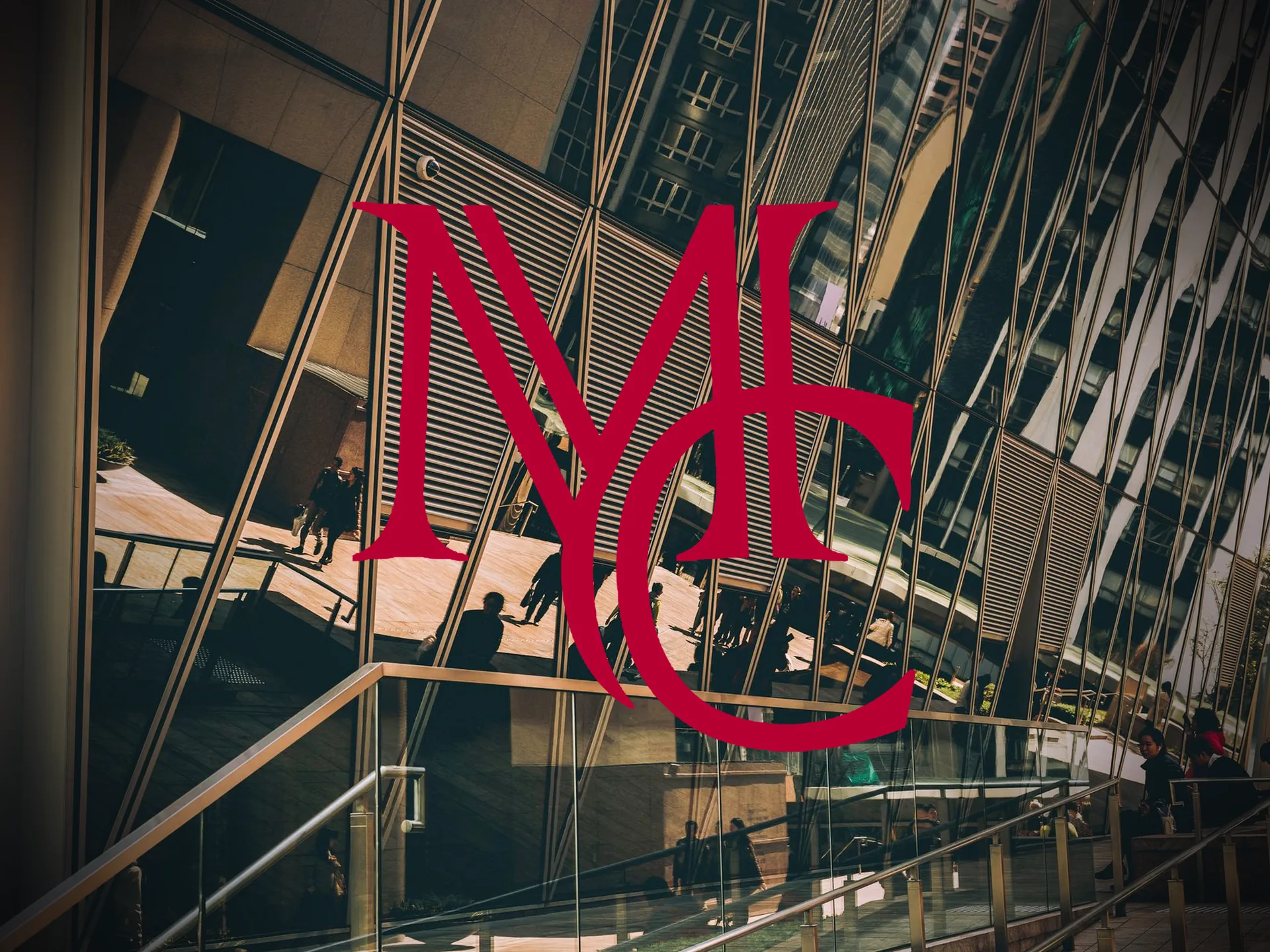 Pedestrians walking beside the glass facade of a modern multi-story office building — MCG