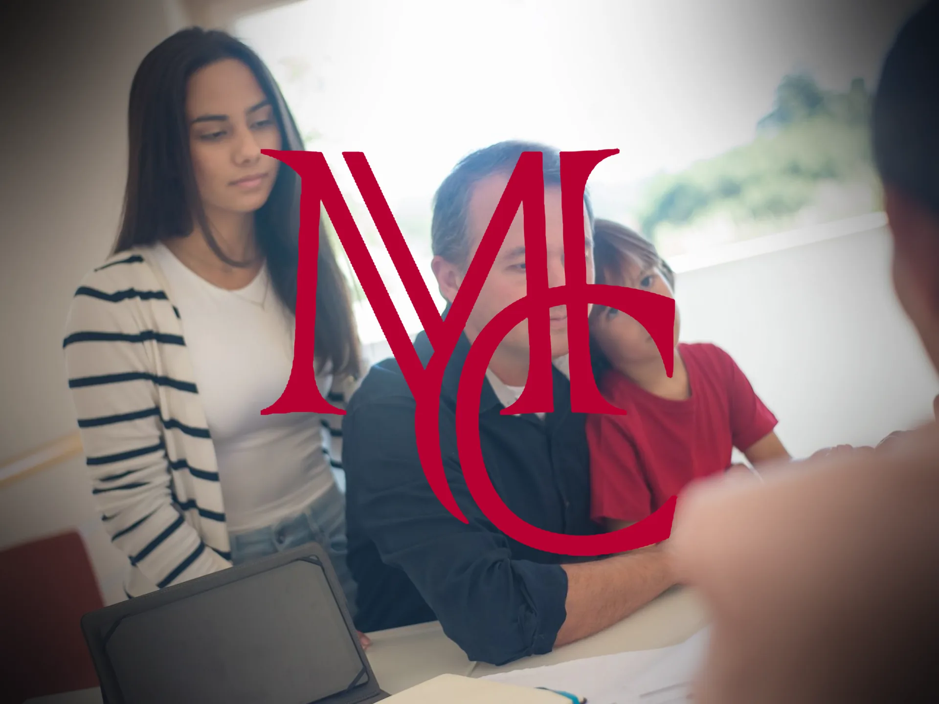 Family reviewing home financing documents with an advisor at a table — MCG