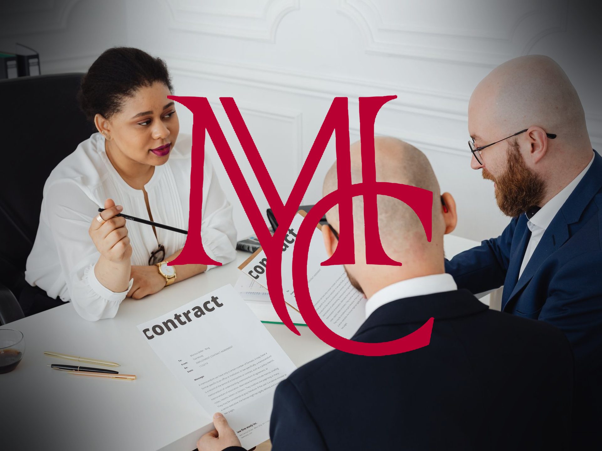 Woman talking with two men reviewing contracts at a table with the crimson Mason Capital Group monogram, illustrating listing agreement terms