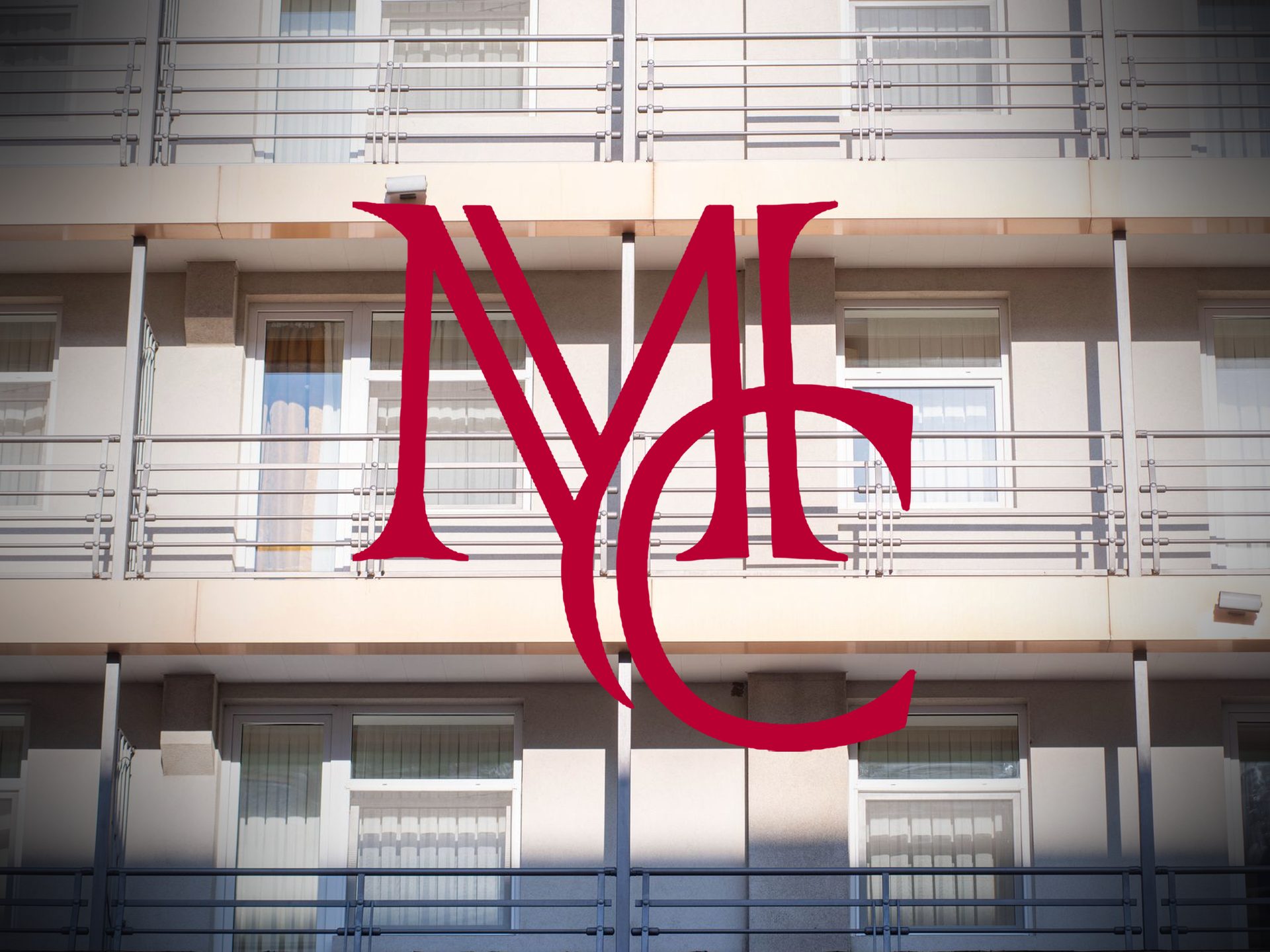 Apartment building exterior with balconies and windows with the crimson Mason Capital Group monogram, illustrating a 1031 exchange on a rental