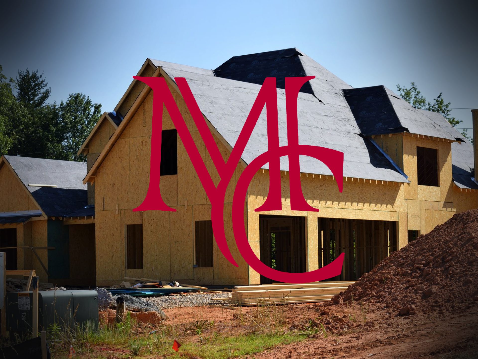 Wood-framed house under construction with the crimson Mason Capital Group monogram, illustrating housing permits and population growth