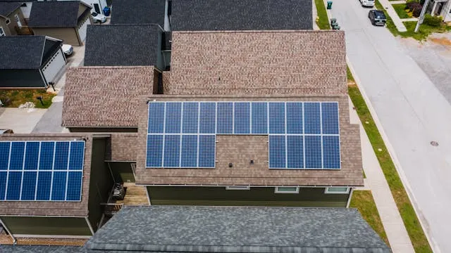 Aerial view of a residential neighborhood showing houses with solar panels installed on their roofs.
