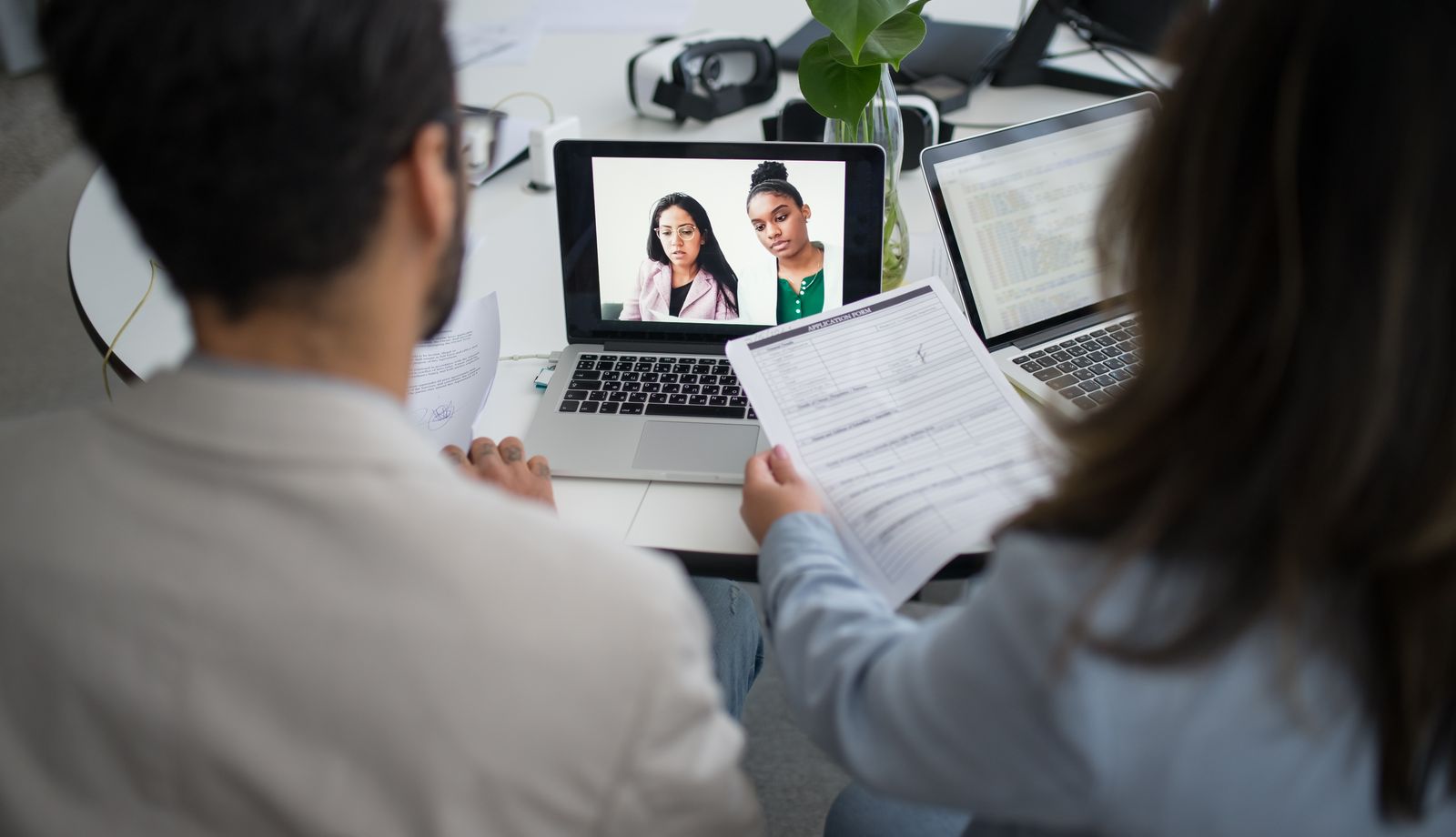 Practice staff conducting a virtual interview with a candidate over laptop video call