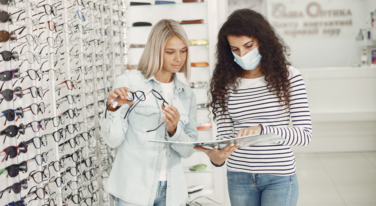 Patients comparing eyeglass frames at an optical shop display
