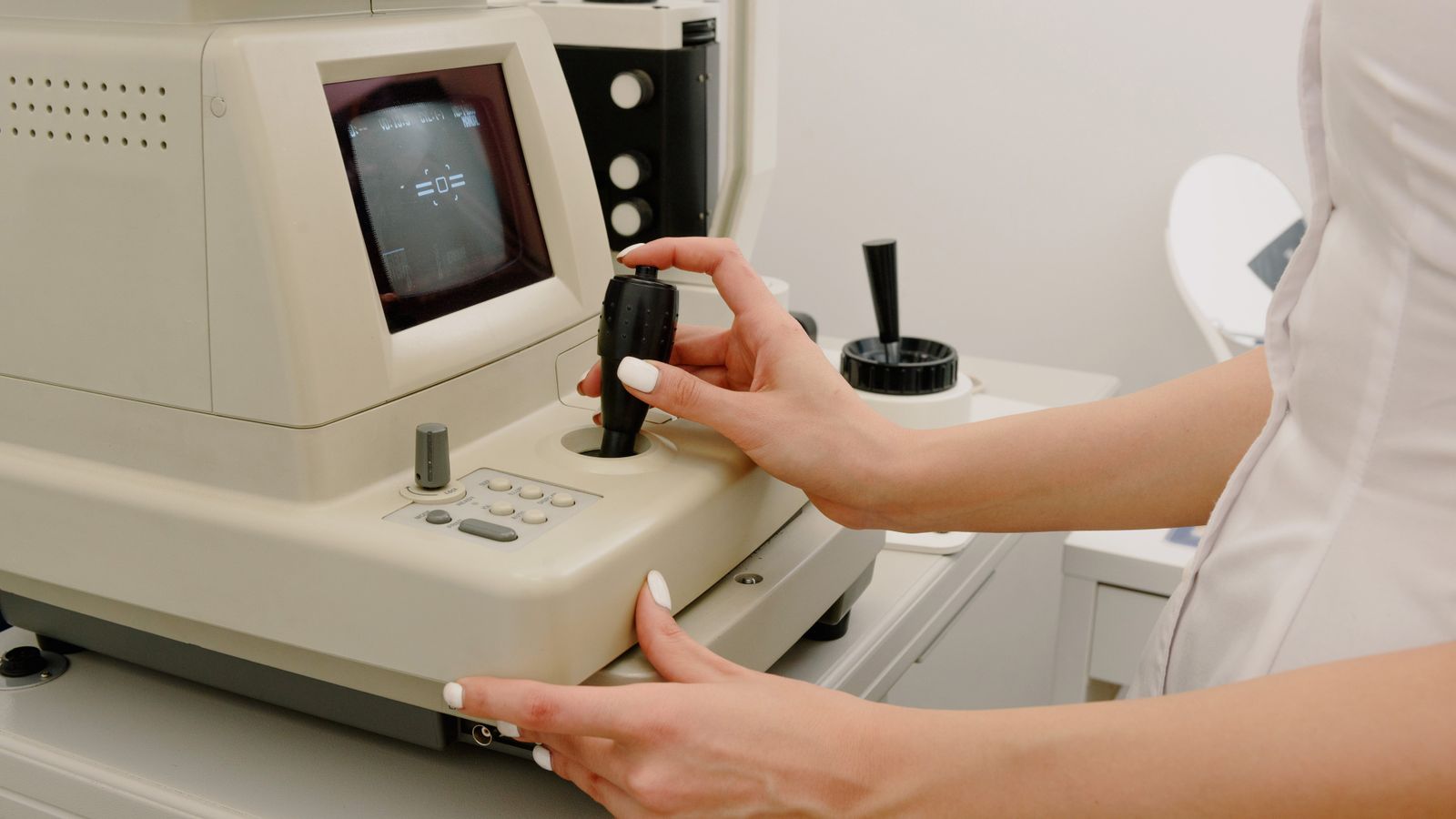 Ophthalmic technician operating corneal topography imaging equipment