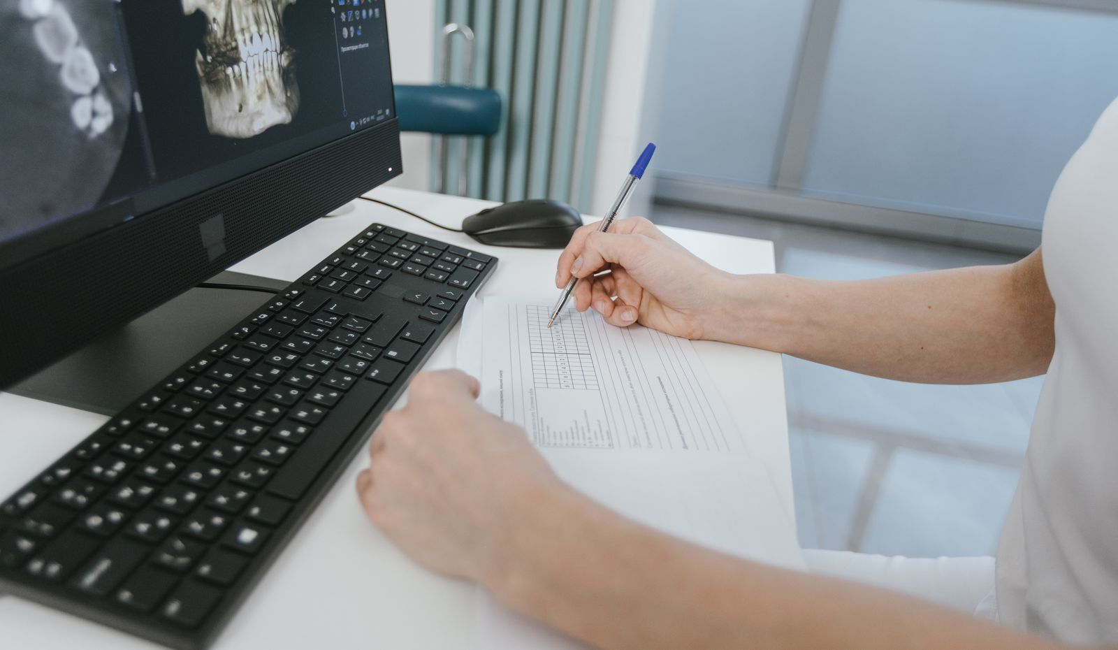 Healthcare worker reviewing results and taking notes at a computer