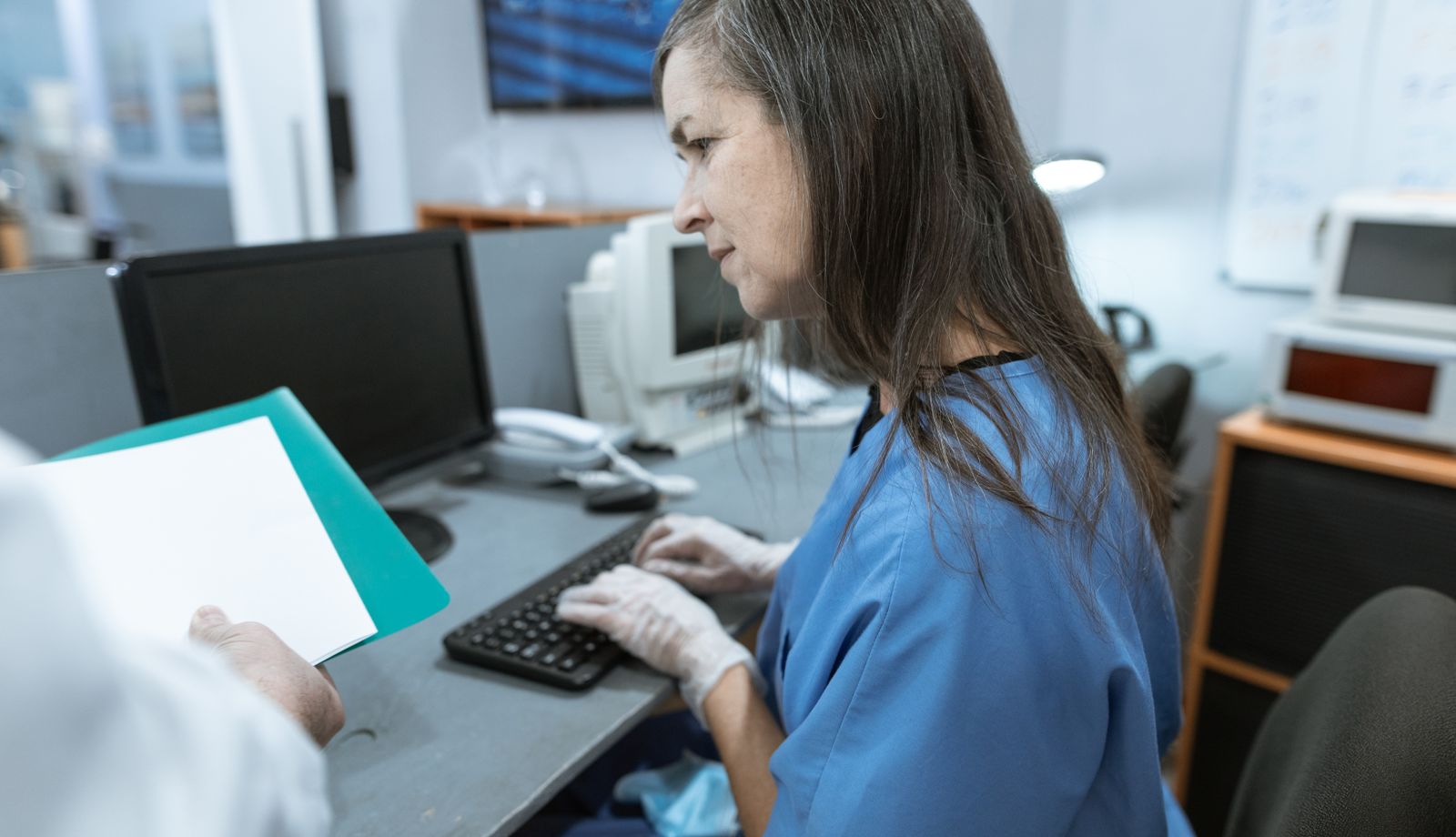 Clinical staff member documenting in the EHR at a medical workstation