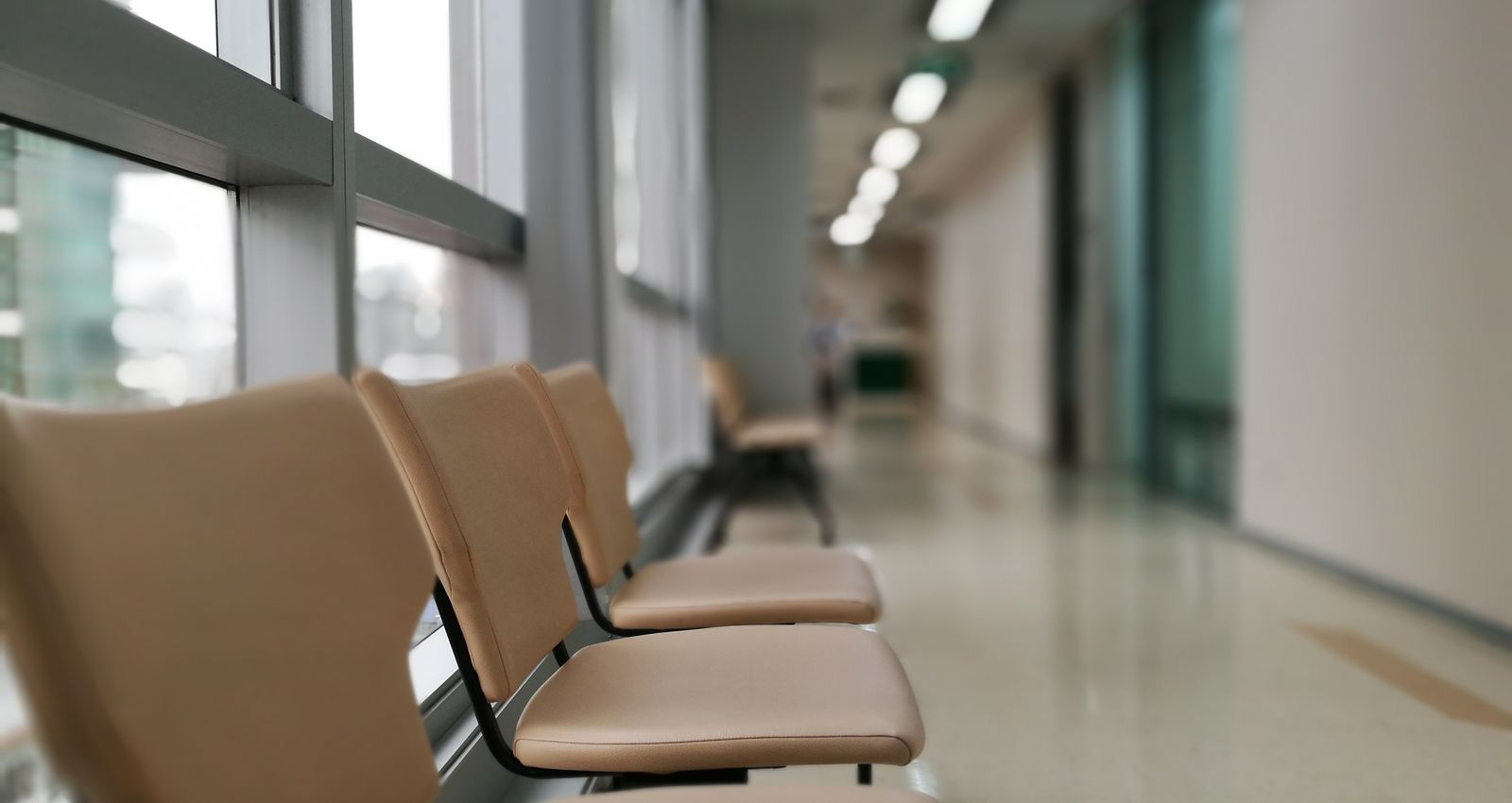 Row of empty chairs in a quiet clinic corridor