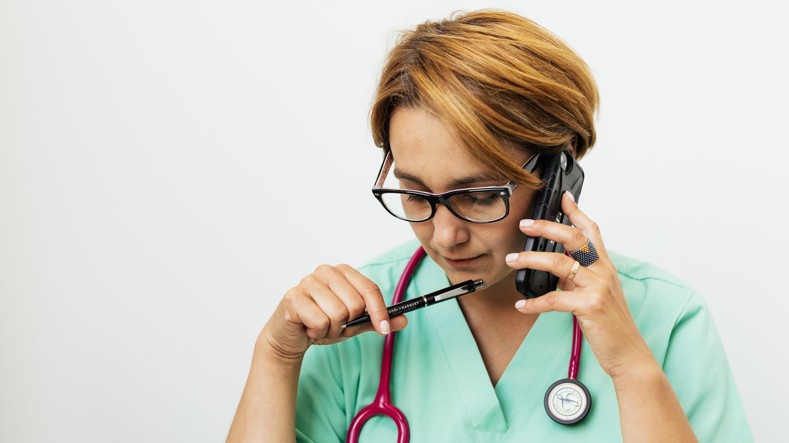Clinician with stethoscope handling an urgent phone call