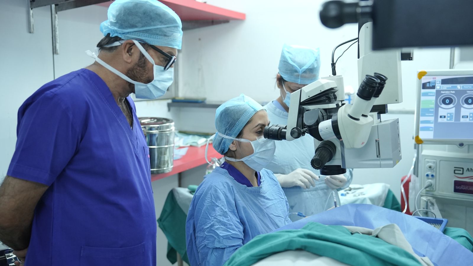 Surgeons performing eye surgery under an operating microscope