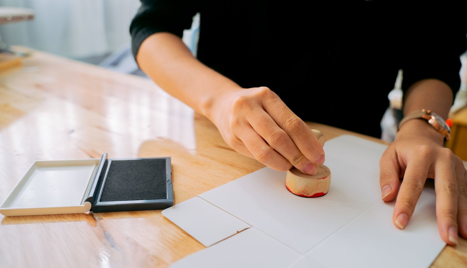 Hand stamping an authorization document at a desk