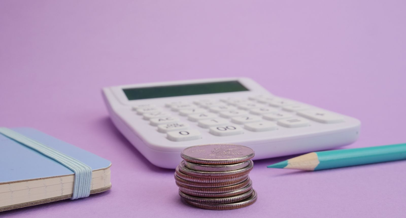Calculator and coins arranged for a cost comparison