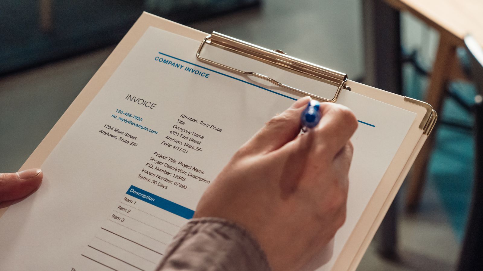 Hand reviewing a medical invoice on a clipboard