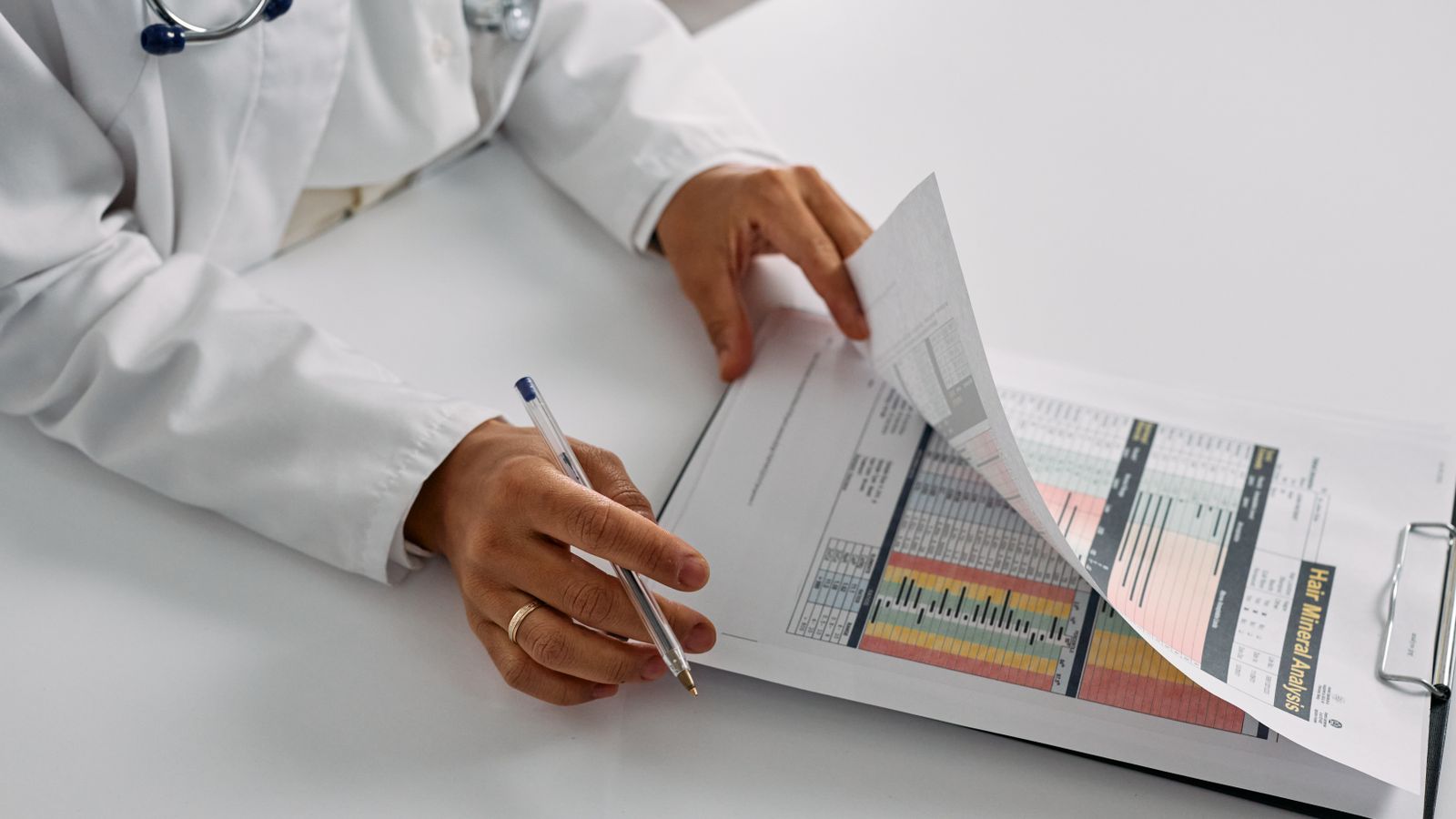 Clinician paging through a coded patient report at a desk