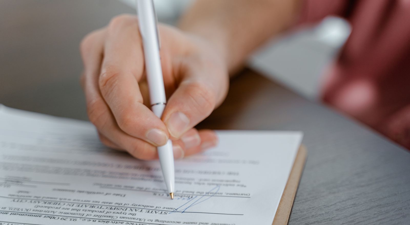 Hand signing a business associate agreement with a pen