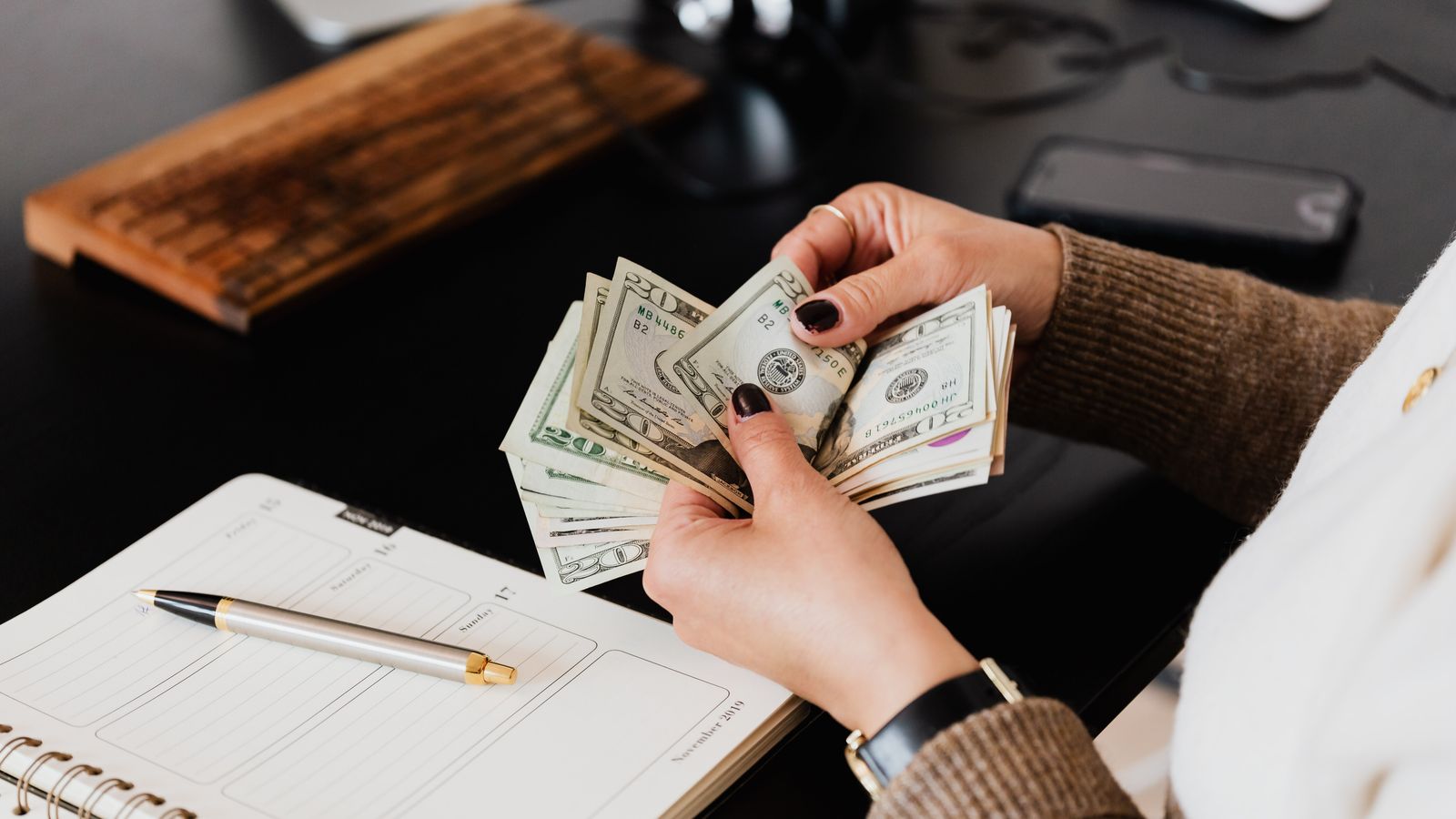 Counting salary payment in dollar bills at a desk