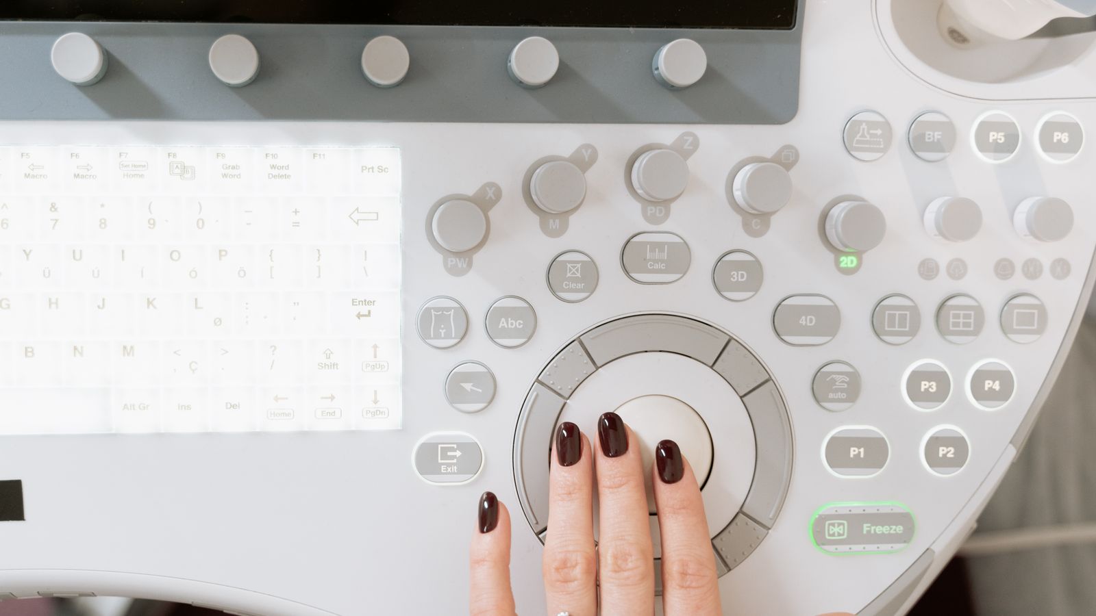 Technician's hand on the control panel of diagnostic equipment