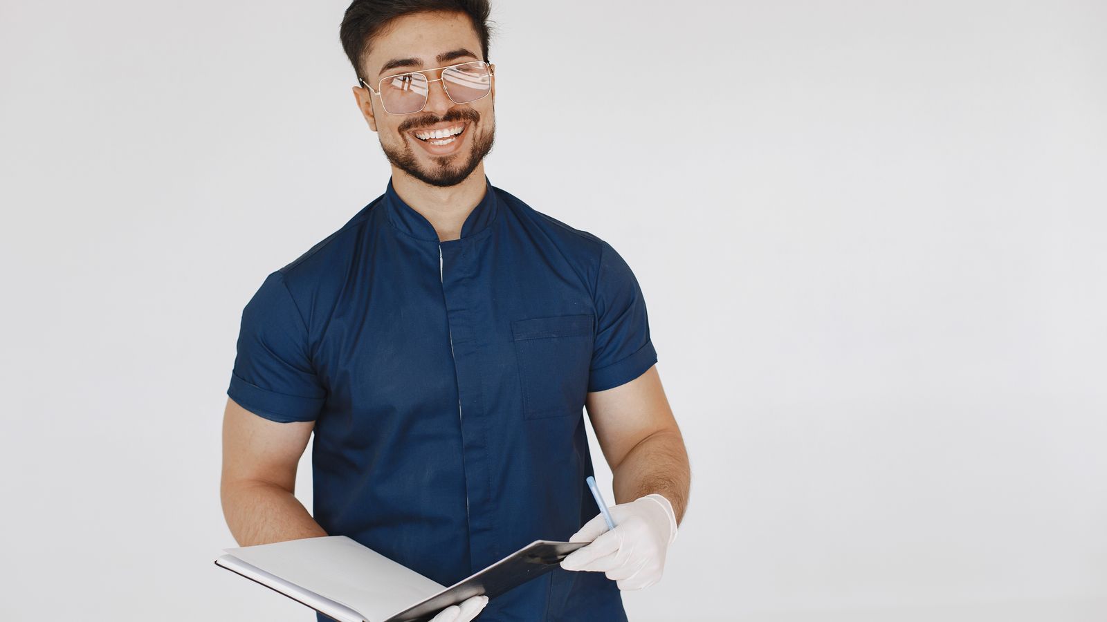 Medical assistant in scrubs holding a patient notebook