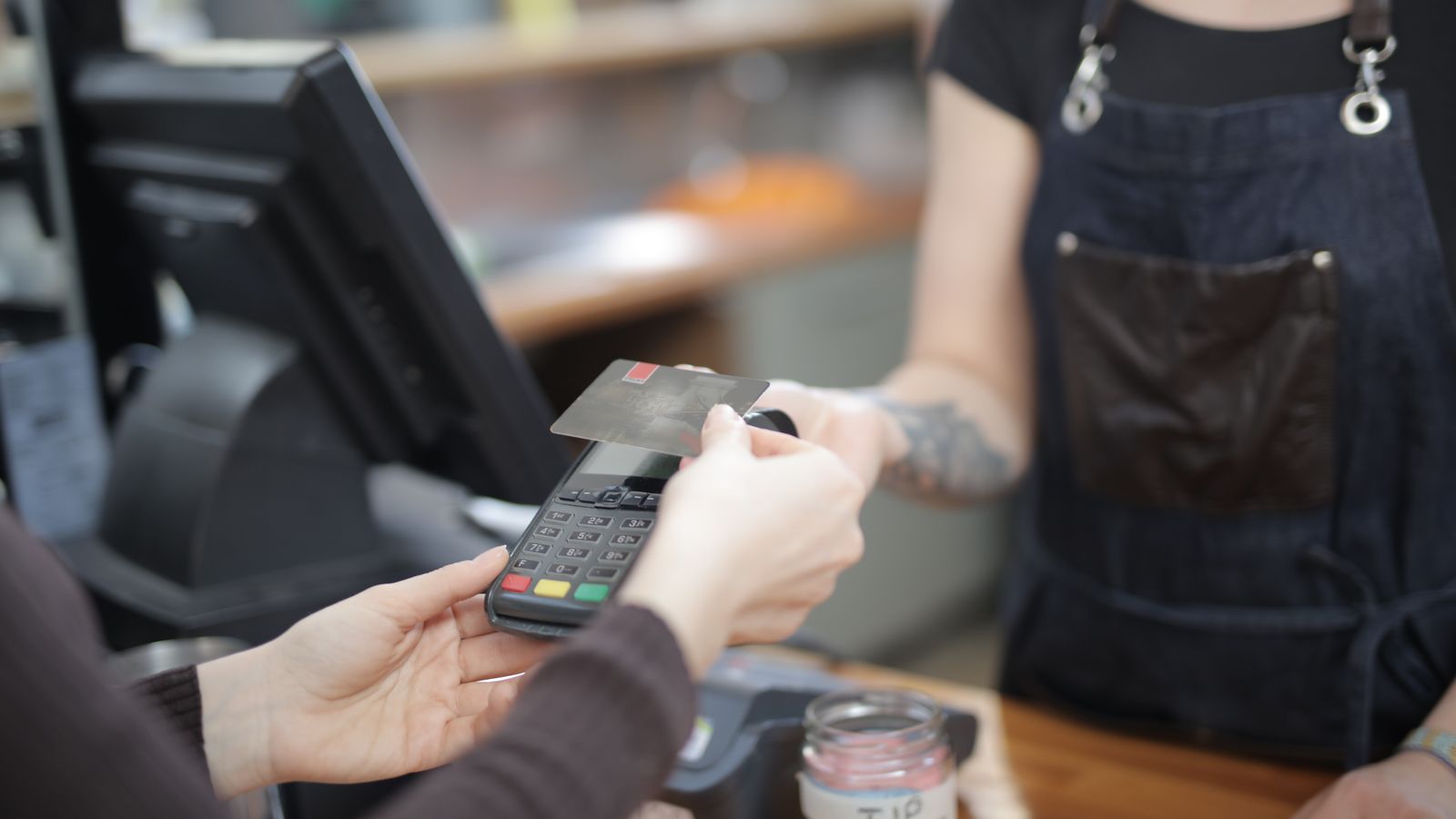 Customer completing a card payment at a retail counter