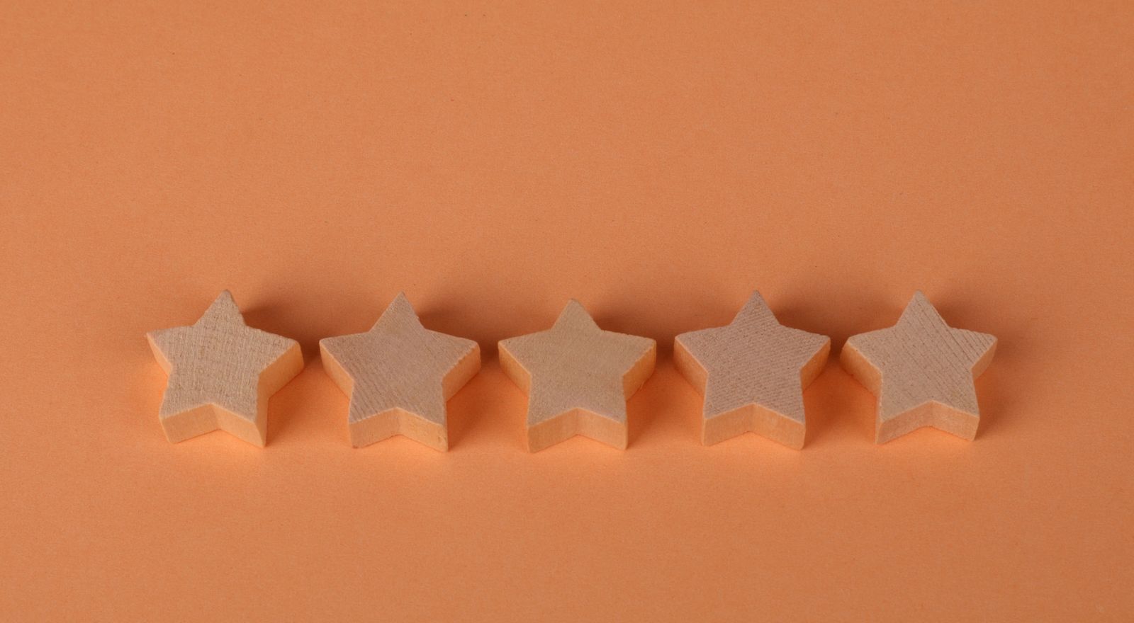 Five wooden stars in a row representing a customer review